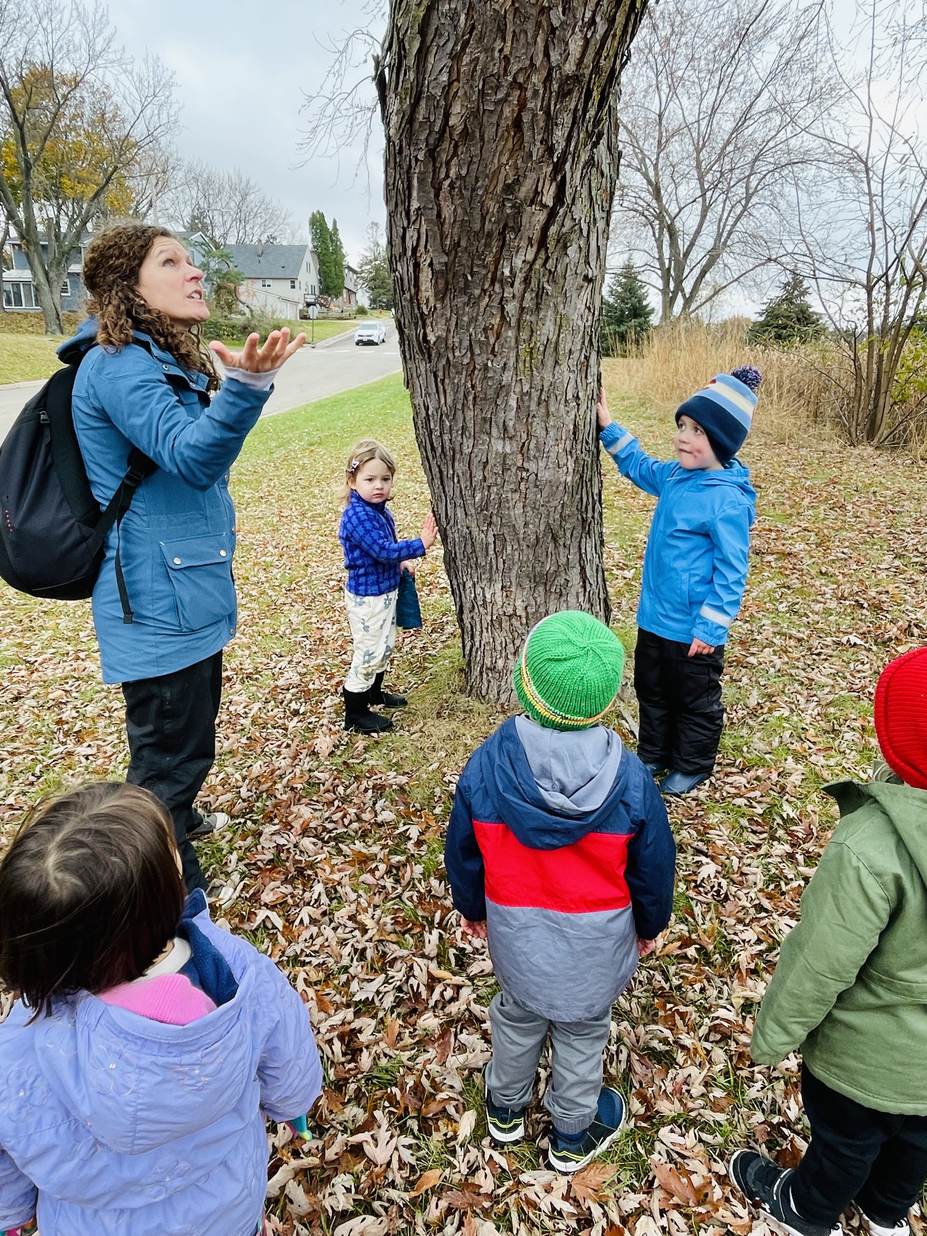 adult and children gathered around a tree